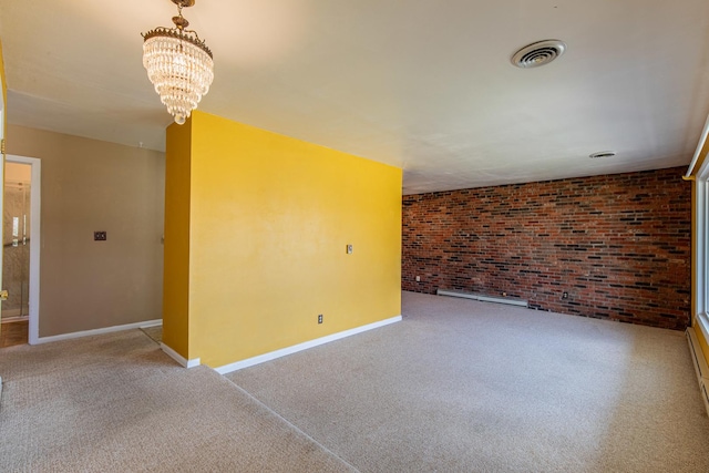 carpeted empty room with brick wall, a notable chandelier, visible vents, and baseboards