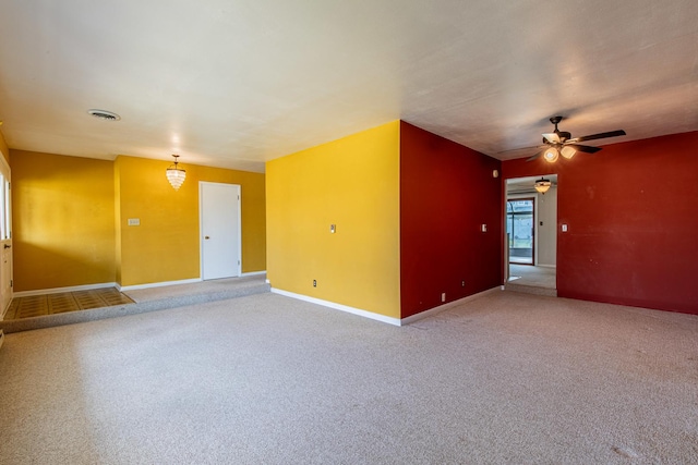 carpeted spare room featuring baseboards, a ceiling fan, and visible vents