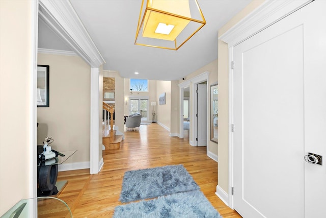 entrance foyer with ornamental molding, baseboards, and wood finished floors