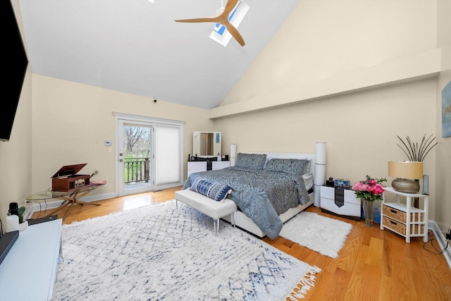bedroom featuring ceiling fan, wood finished floors, high vaulted ceiling, and access to exterior