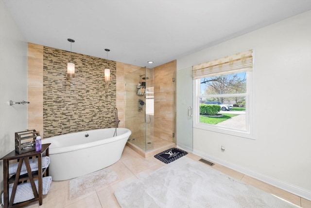 full bath featuring a stall shower, a soaking tub, tile patterned floors, visible vents, and baseboards