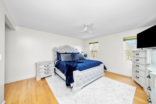 bedroom with baseboards, light wood finished floors, and a ceiling fan