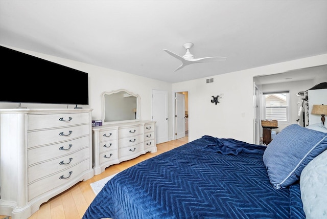 bedroom with light wood finished floors, visible vents, and ceiling fan