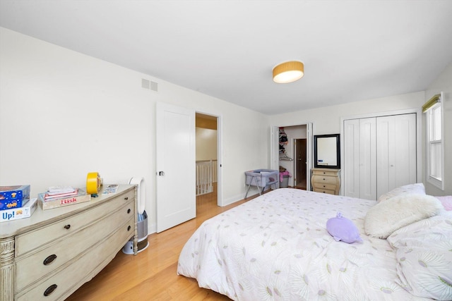 bedroom with light wood-type flooring, baseboards, and visible vents