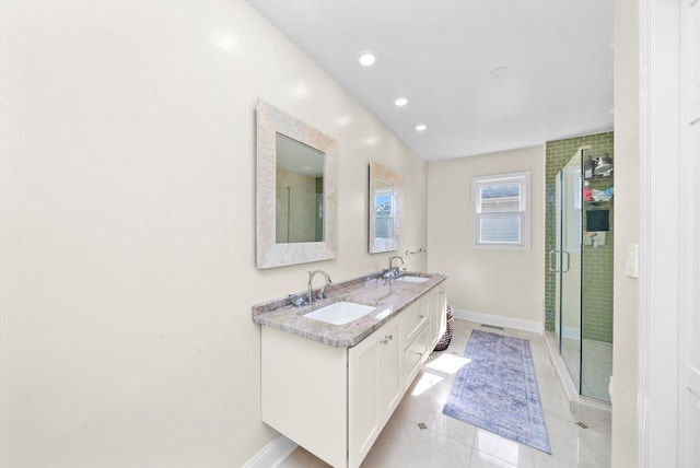 full bath with baseboards, a shower stall, tile patterned flooring, and a sink