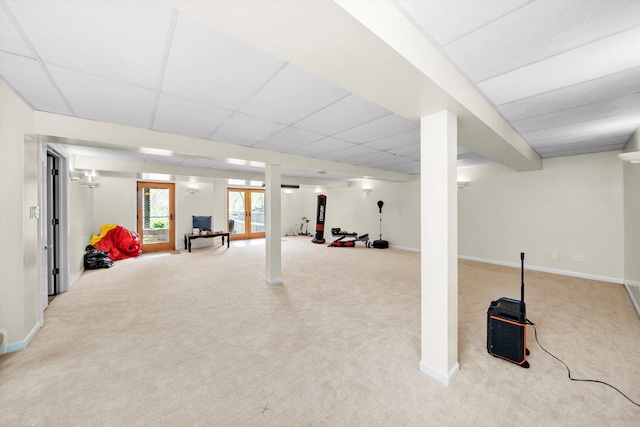 basement featuring carpet flooring, a drop ceiling, and baseboards