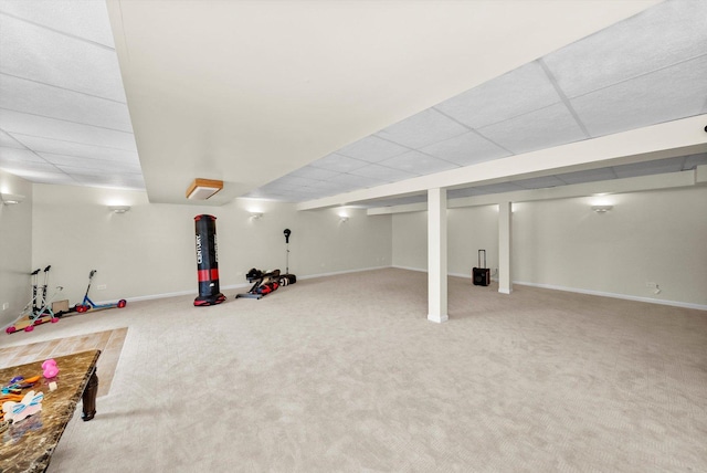 finished below grade area with carpet, a drop ceiling, and baseboards