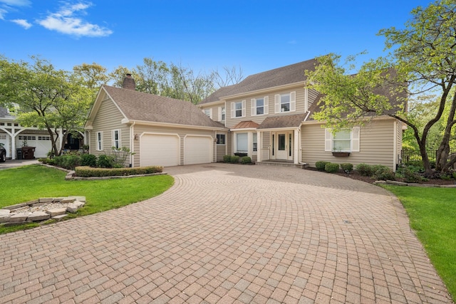 717 Stonebridge Rd, Frankfort, IL 60423 - view of front of home featuring decorative driveway, a garage, a front yard, and a chimney