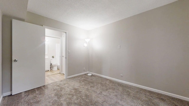 912 Crescent Dr Unit 2-4, Champaign, IL 61821 - unfurnished bedroom featuring carpet floors, a textured ceiling, baseboards, and ensuite bathroom
