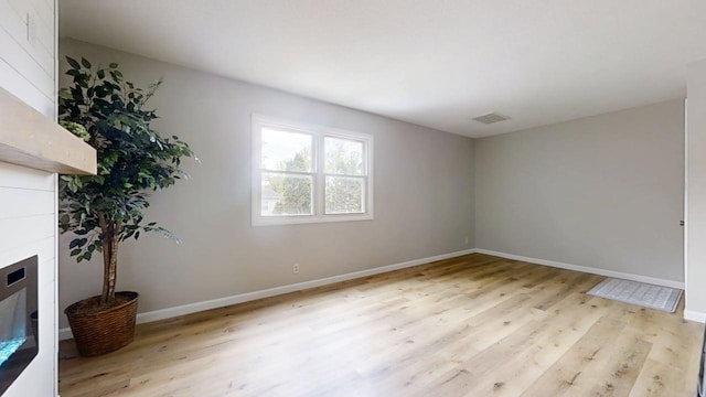 912 Crescent Dr Unit 2-4, Champaign, IL 61821 - spare room with a tiled fireplace, light wood-style floors, and baseboards
