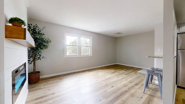 912 Crescent Dr Unit 2-4, Champaign, IL 61821 - unfurnished living room with light wood-type flooring, a fireplace, and baseboards