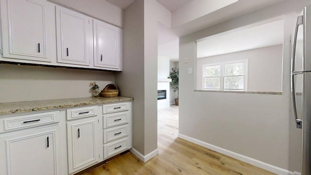 912 Crescent Dr Unit 2-4, Champaign, IL 61821 - bar with light wood-style flooring, baseboards, and stainless steel fridge