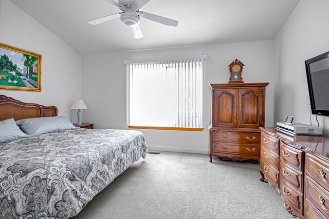 bedroom with light carpet, baseboards, a ceiling fan, and lofted ceiling