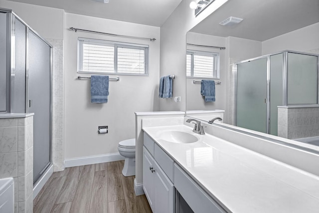 full bathroom featuring visible vents, baseboards, a shower stall, vanity, and wood finished floors