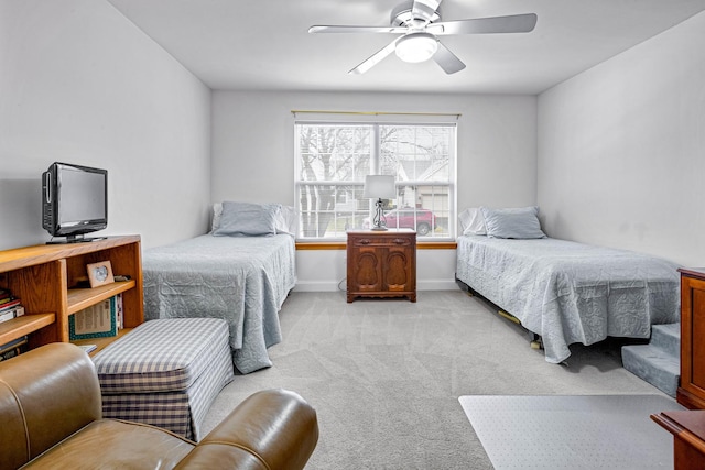 bedroom with light carpet, baseboards, and a ceiling fan