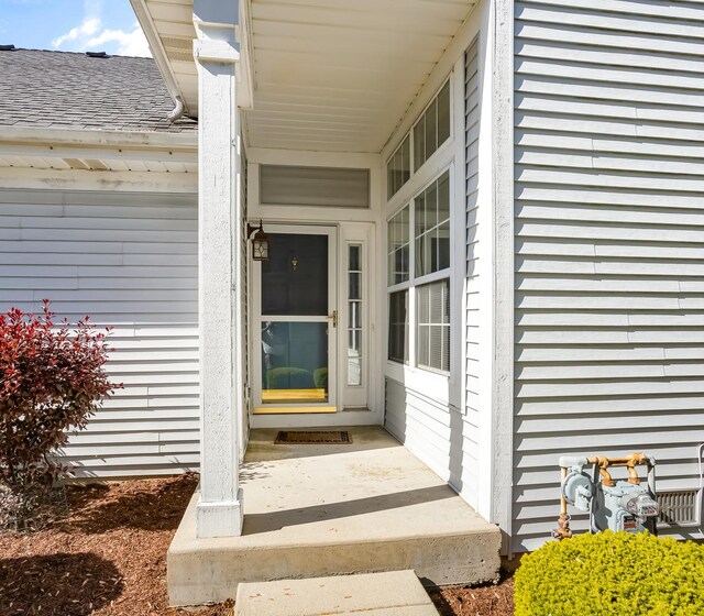property entrance featuring roof with shingles