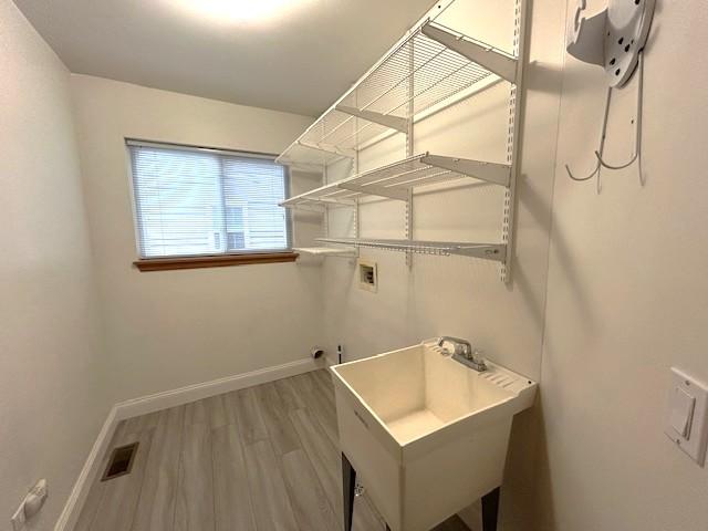 laundry room with baseboards, visible vents, laundry area, hookup for a washing machine, and wood finished floors