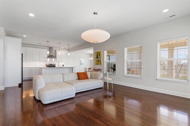living room featuring baseboards, dark wood finished floors, visible vents, and recessed lighting