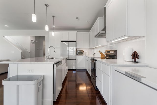 kitchen with tasteful backsplash, dark wood-style flooring, a center island with sink, stainless steel appliances, and a sink