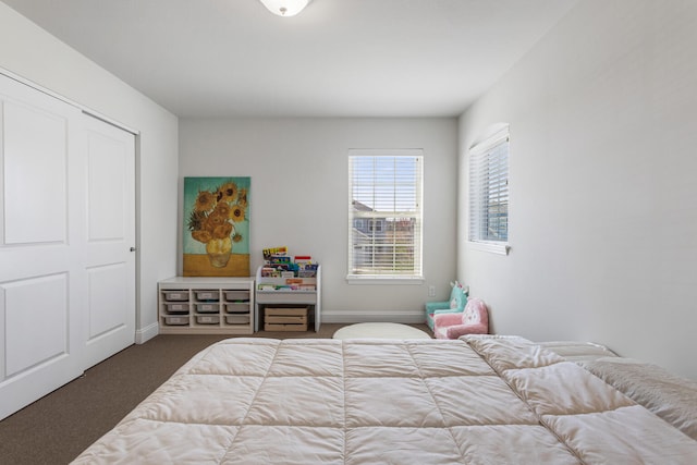 bedroom with baseboards and dark carpet