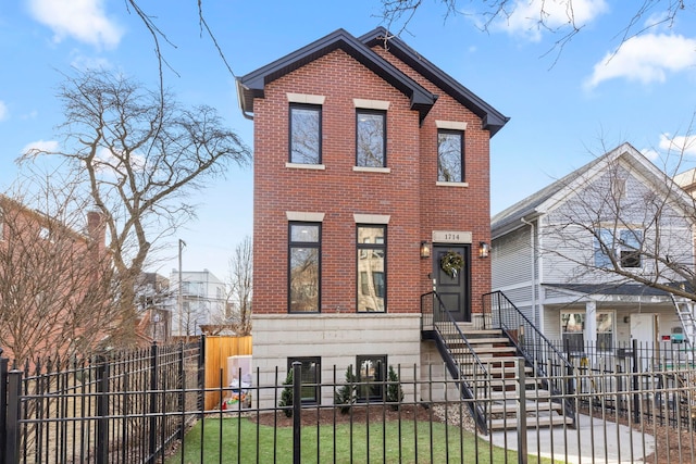 view of front of home featuring brick siding and a fenced front yard