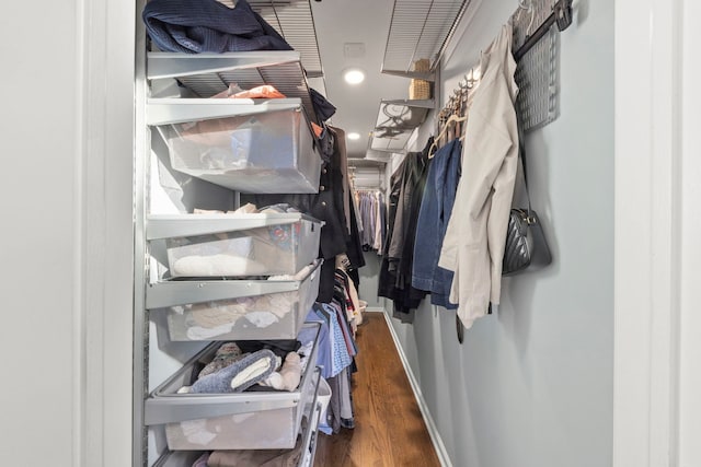 walk in closet with wood finished floors