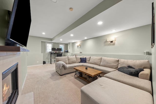 living area with a warm lit fireplace, baseboards, recessed lighting, and light colored carpet