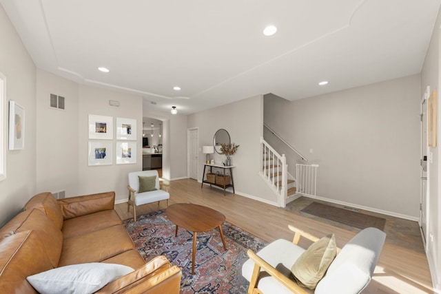 living room with wood finished floors, recessed lighting, baseboards, and stairs