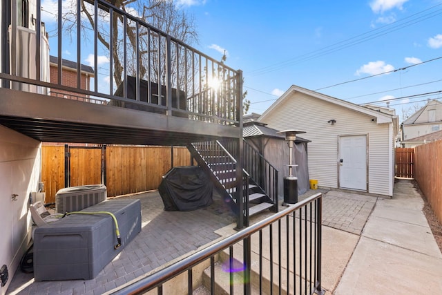 exterior space featuring stairway, cooling unit, fence, and an outbuilding