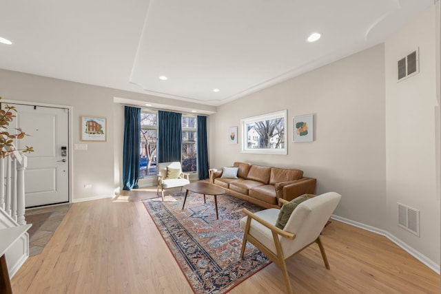 living area with recessed lighting, visible vents, baseboards, and light wood-style flooring