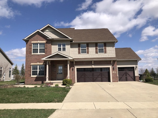 craftsman house with concrete driveway, a shingled roof, an attached garage, brick siding, and a front lawn