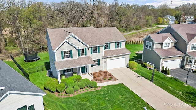 view of front of home with fence, a shingled roof, a front lawn, concrete driveway, and an attached garage
