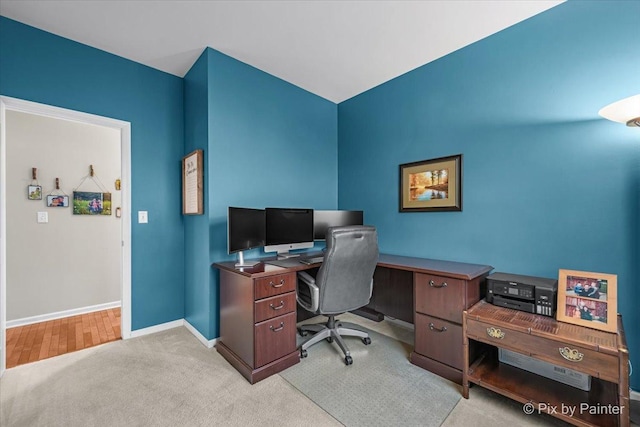 office featuring baseboards and light colored carpet