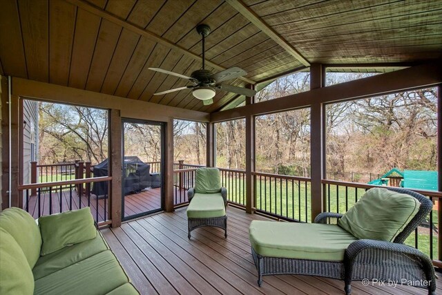 sunroom with beamed ceiling and ceiling fan