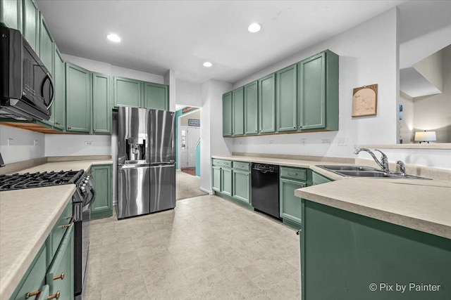 kitchen with black appliances, green cabinets, recessed lighting, and a sink