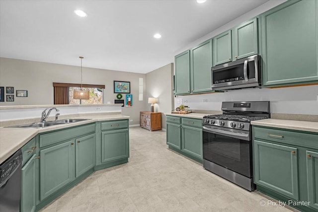 kitchen with green cabinetry, a sink, stainless steel appliances, light countertops, and recessed lighting