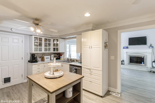 kitchen featuring a sink, glass insert cabinets, white cabinets, a ceiling fan, and light countertops