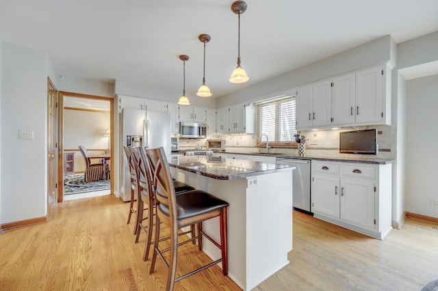 2624 Haddassah Dr, Naperville, IL 60565 - kitchen featuring light wood-style flooring, a center island, appliances with stainless steel finishes, and white cabinets