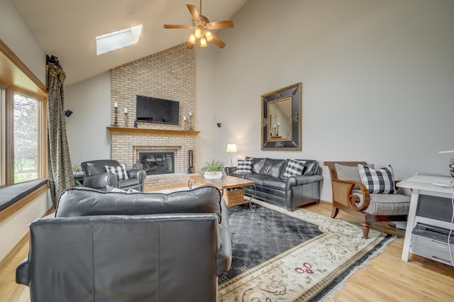 2624 Haddassah Dr, Naperville, IL 60565 - living room featuring a brick fireplace, light wood-style floors, a skylight, high vaulted ceiling, and ceiling fan