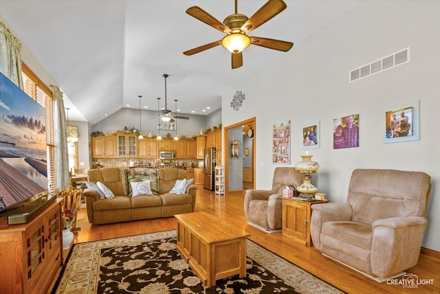 living room featuring high vaulted ceiling, light wood-style flooring, a ceiling fan, visible vents, and recessed lighting