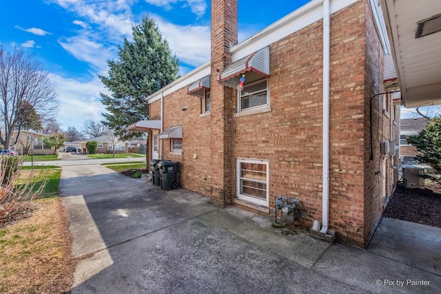 view of home's exterior featuring central AC unit and brick siding
