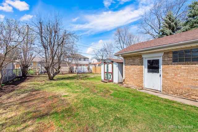 view of yard with a shed, a fenced backyard, and an outbuilding