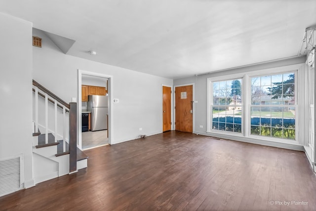 unfurnished living room with stairway, dark wood-style floors, baseboards, and visible vents