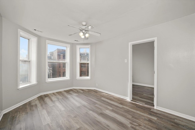 6611 S Peoria St, Chicago, IL 60621 - empty room featuring healthy amount of natural light, wood finished floors, and ceiling fan