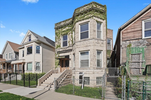 6611 S Peoria St, Chicago, IL 60621 - view of front of property featuring a gate, a fenced front yard, and stone siding