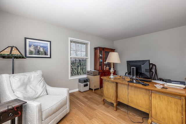 office space with light wood-type flooring and baseboards