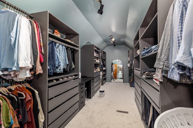 spacious closet with light carpet and vaulted ceiling