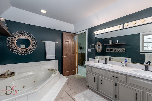 bathroom featuring tile patterned floors, a jetted tub, double vanity, and a sink