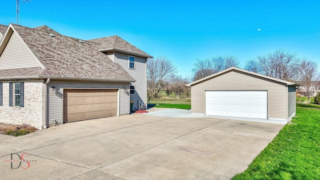view of property exterior featuring a garage, roof with shingles, and an outbuilding