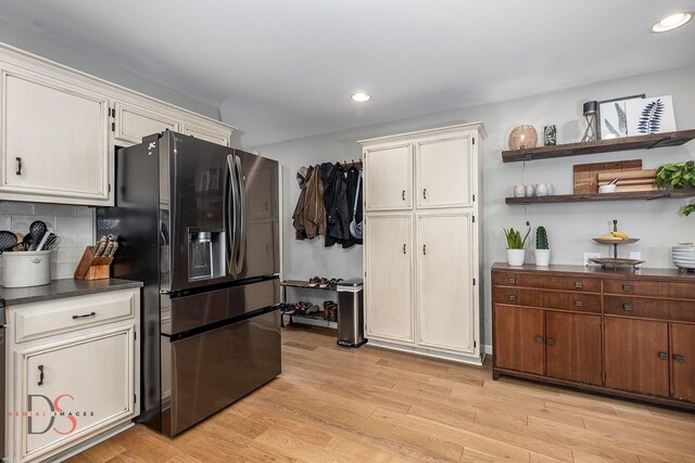 kitchen featuring recessed lighting, light wood finished floors, open shelves, and stainless steel refrigerator with ice dispenser